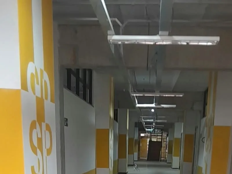 Corredor com pilares pintados em amarelo e branco